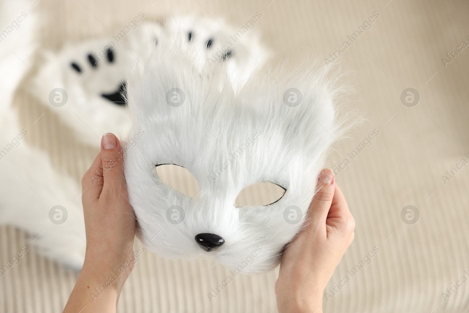 Photo of Quadrobics. Woman with furry cat mask on blurred background, closeup