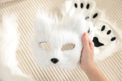 Photo of Quadrobics. Woman with furry cat mask near sofa, closeup