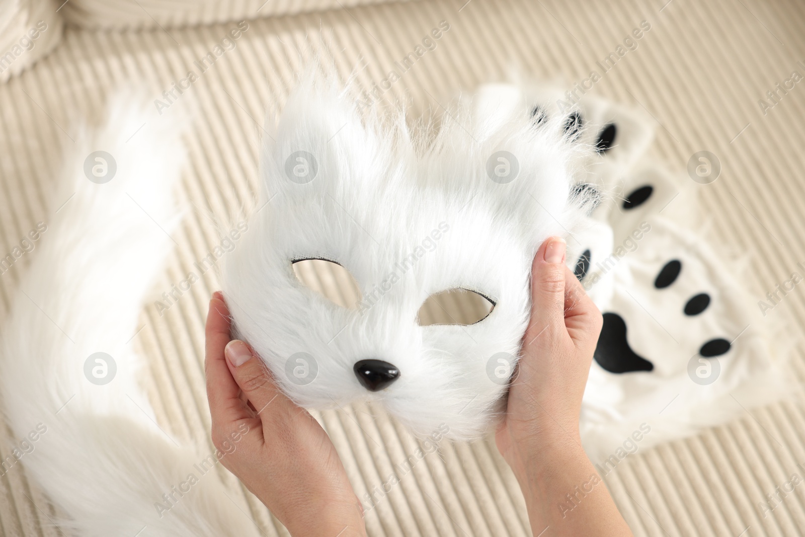 Photo of Quadrobics. Woman with furry cat mask near sofa, closeup