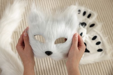 Photo of Quadrobics. Woman with furry cat mask near sofa, closeup