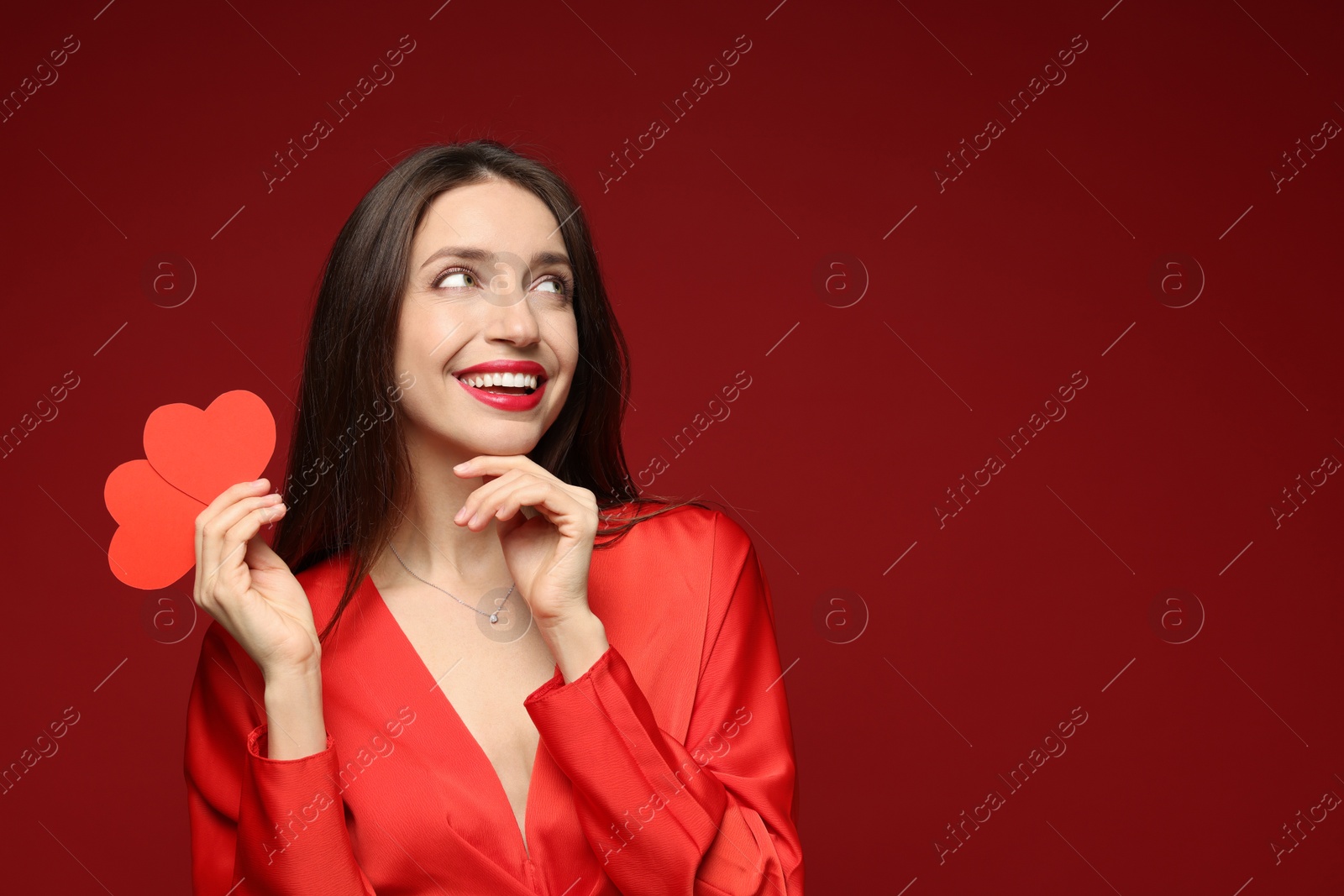 Photo of Happy Valentine's Day. Beautiful woman with paper hearts on red background. Space for text