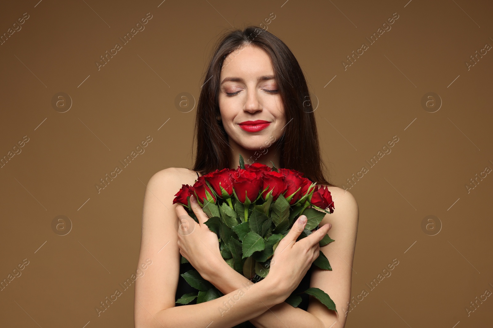 Photo of Happy Valentine's Day. Beautiful woman with bouquet of roses on brown background