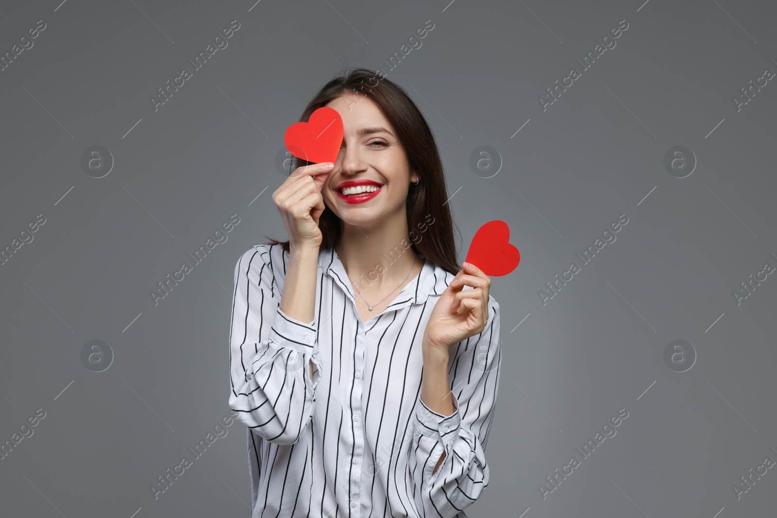 Photo of Happy Valentine's Day. Beautiful woman with paper hearts on grey background