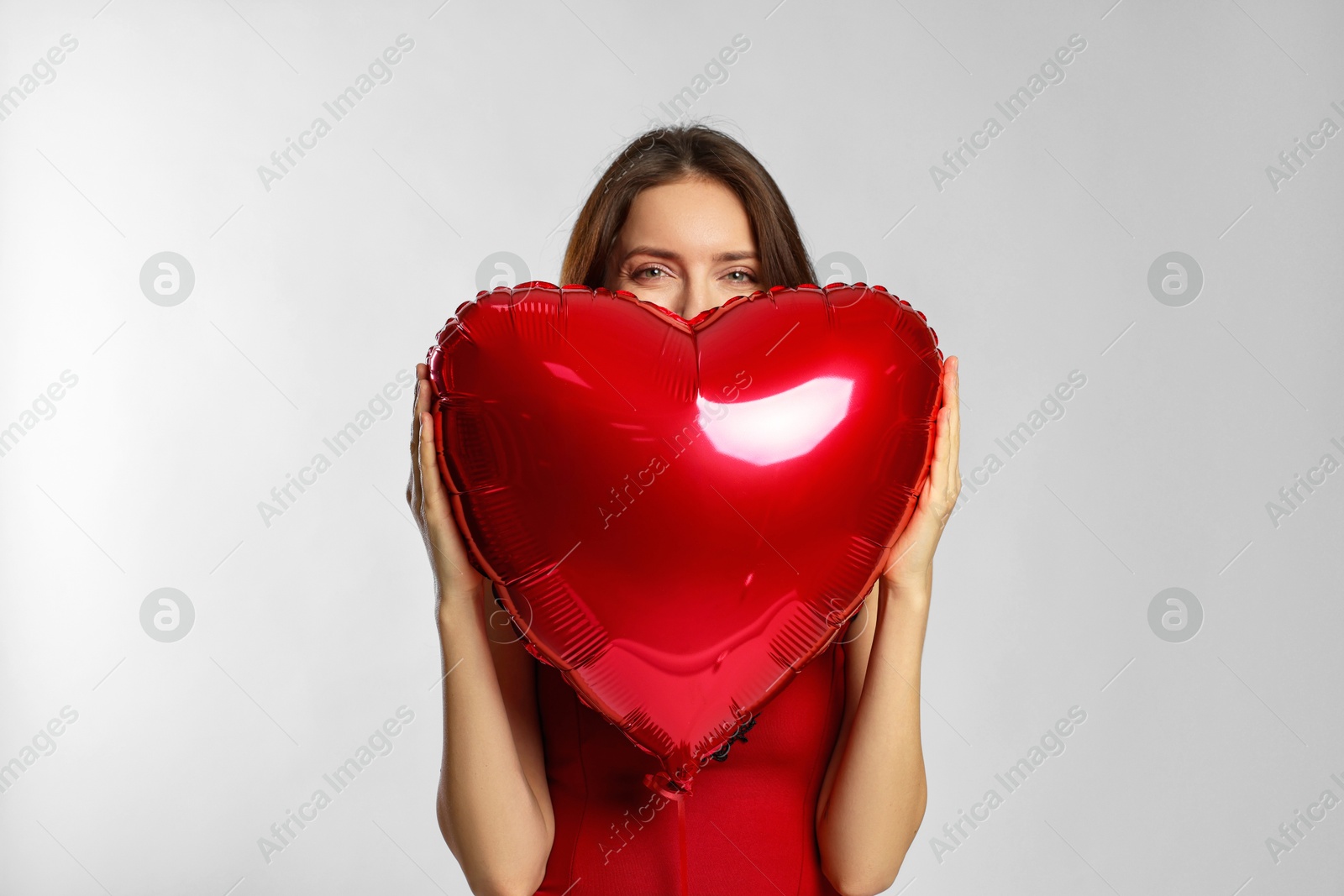 Photo of Happy Valentine's Day. Beautiful woman with heart shaped balloon on white background