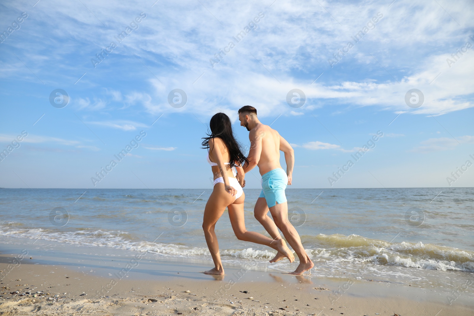 Photo of Lovely young couple running together on beach