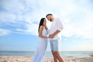 Photo of Happy young couple at beach on sunny day