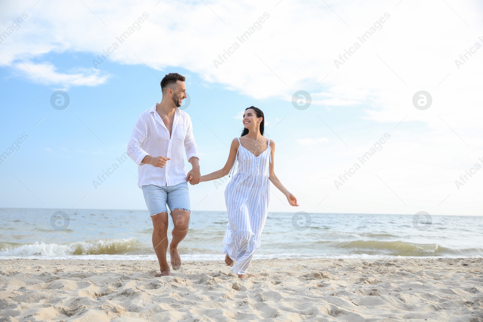 Photo of Happy young couple running together on beach