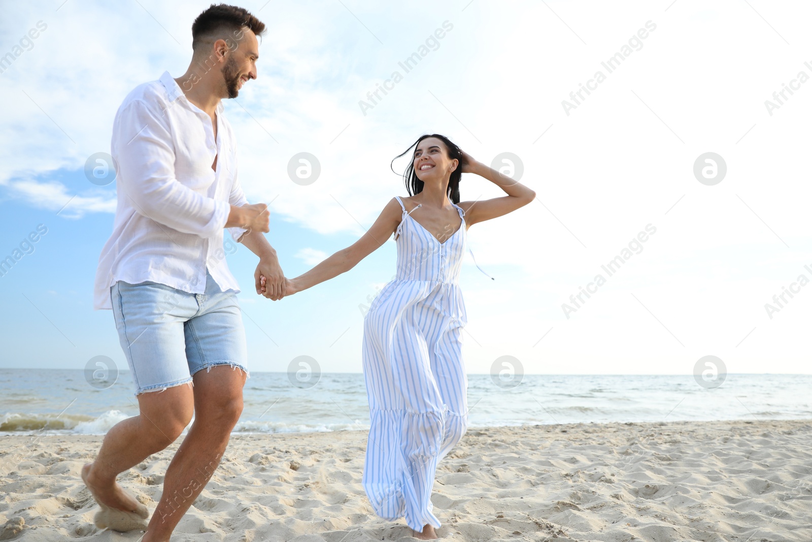 Photo of Happy young couple running together on beach