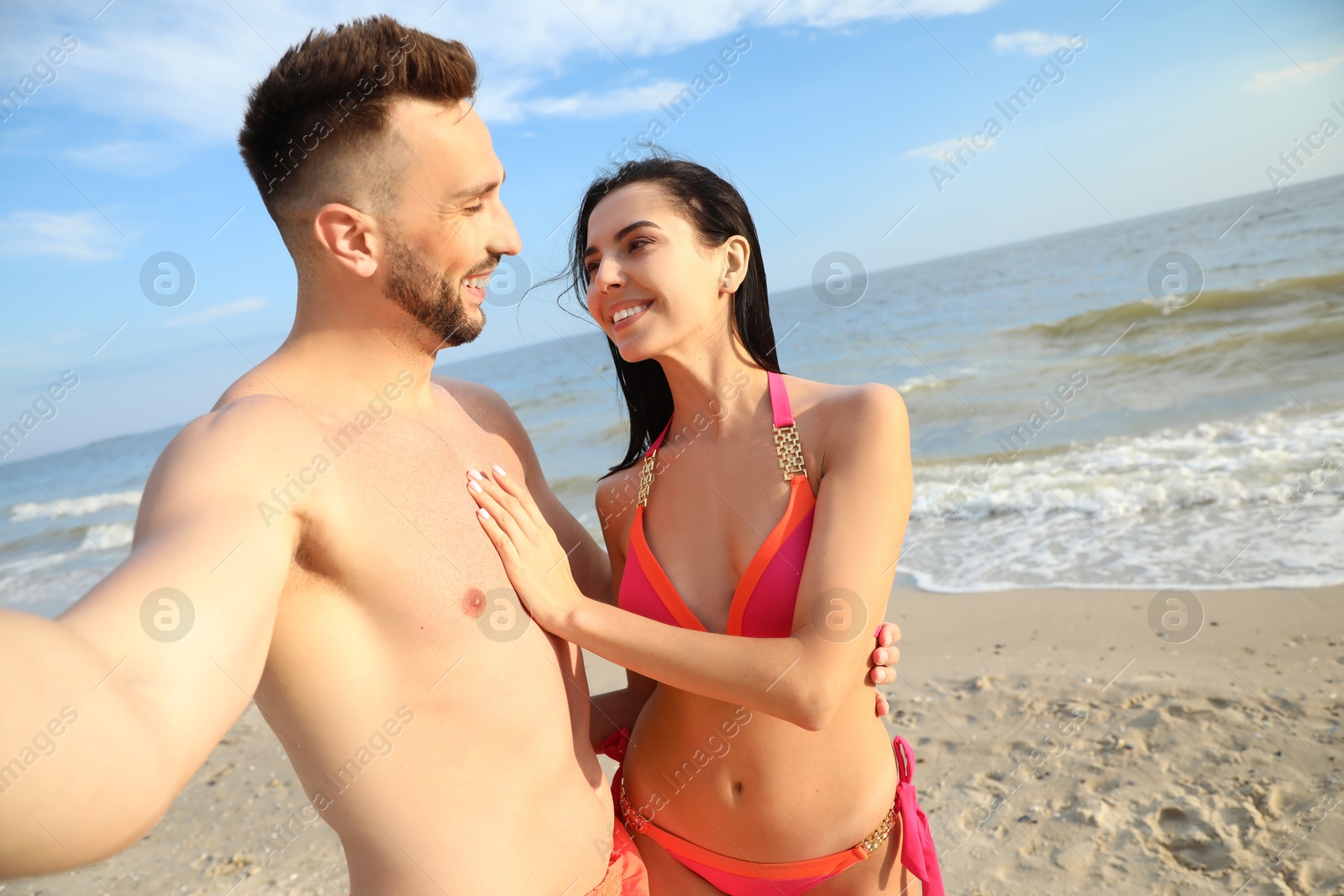 Photo of Happy young couple taking selfie on beach