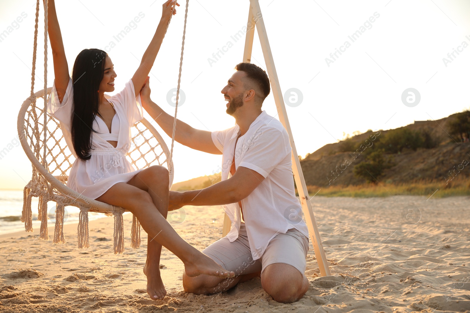 Photo of Happy young couple on beach at sunset