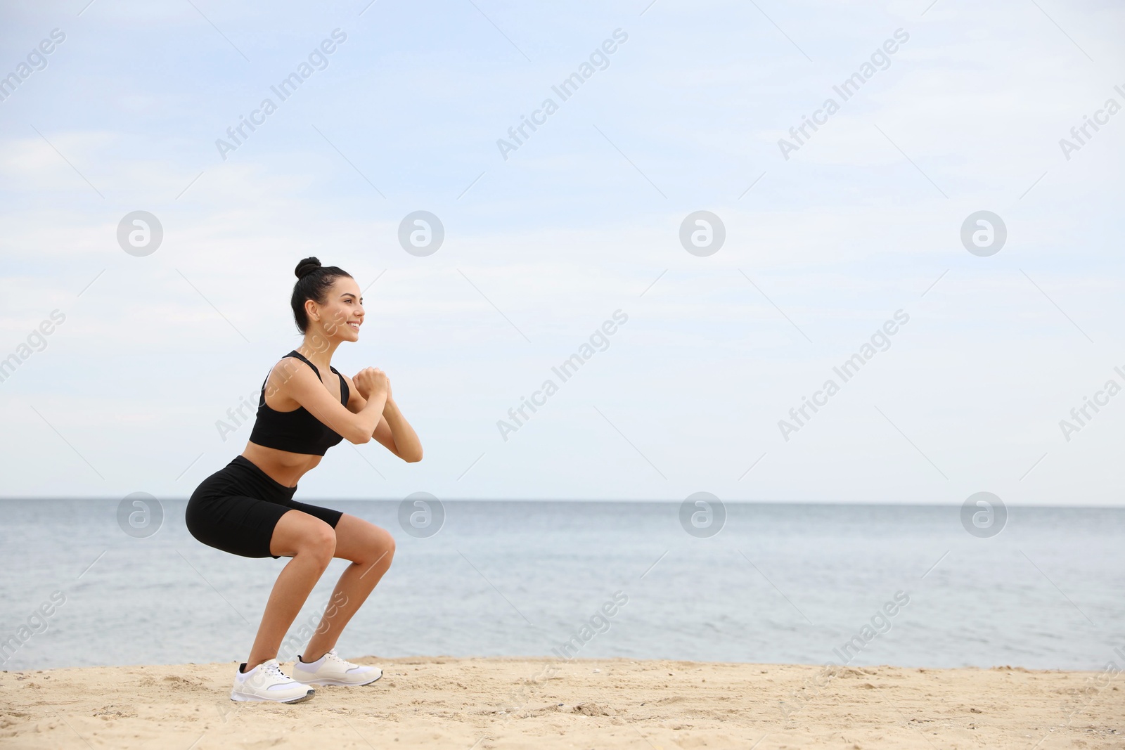 Photo of Young woman doing exercise on beach, space for text. Body training