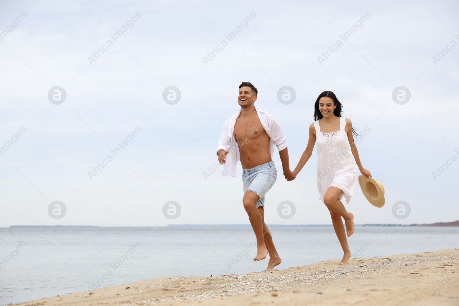 Photo of Lovely couple having fun on beautiful beach. Space for text