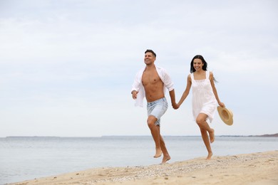 Photo of Lovely couple having fun on beautiful beach. Space for text