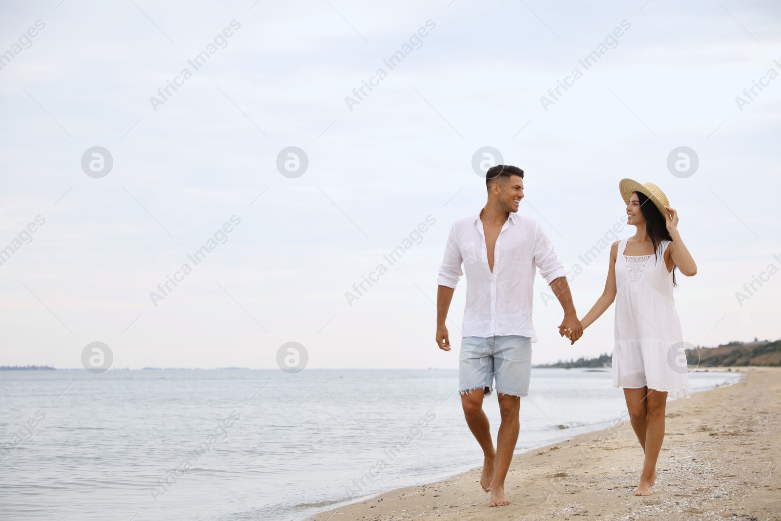 Photo of Lovely couple walking on beach. Space for text