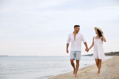 Photo of Lovely couple walking on beach. Space for text