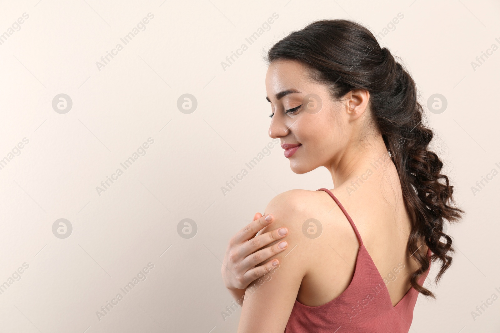 Photo of Young woman with beautiful hairstyle on beige background. Space for text