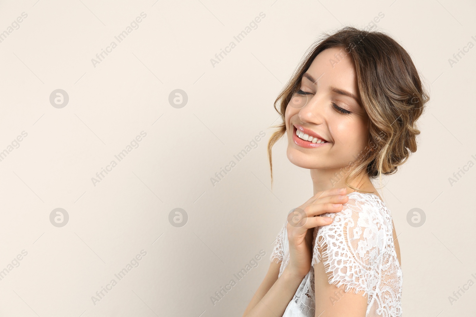 Photo of Young woman with beautiful hairstyle on beige background. Space for text