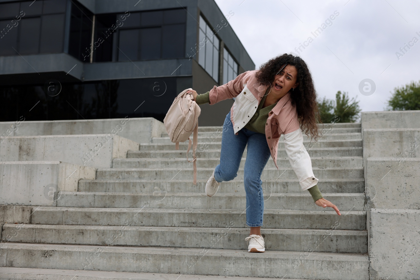 Photo of Woman falling on stairs outdoors. Dangerous accident