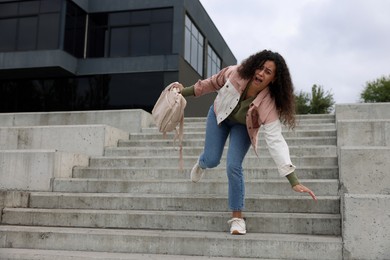 Photo of Woman falling on stairs outdoors. Dangerous accident