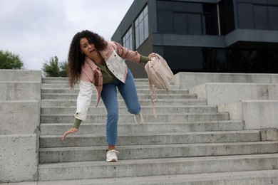 Photo of Woman falling on stairs outdoors. Dangerous accident