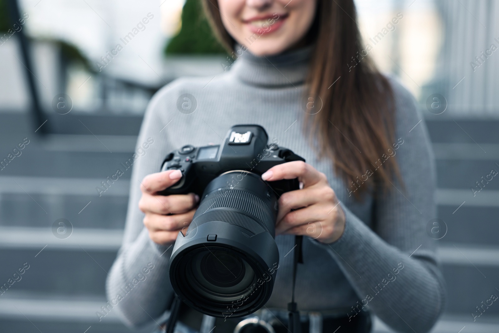 Photo of Professional photographer with digital camera outdoors, closeup