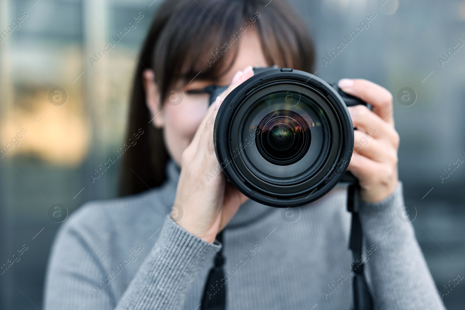 Photo of Professional photographer taking picture with camera outdoors, selective focus