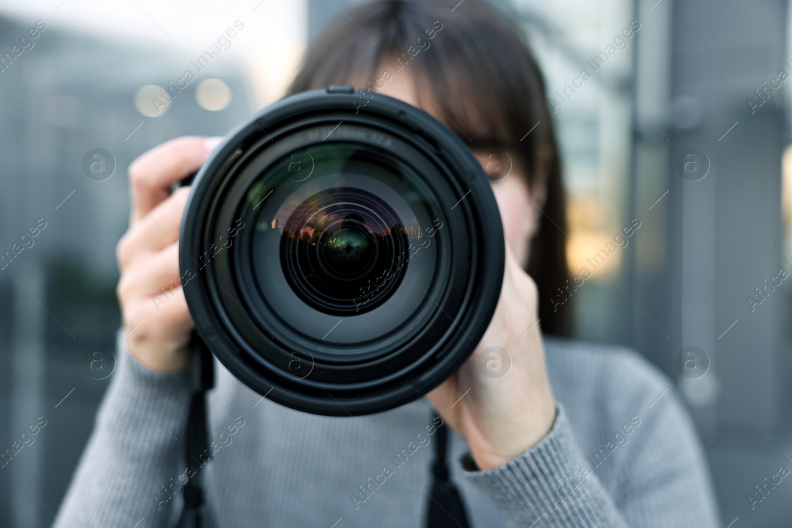 Photo of Professional photographer taking picture with camera outdoors, selective focus