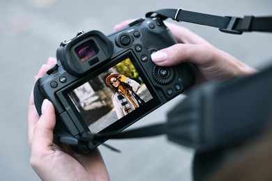 Photo of Professional photographer with digital camera outdoors, closeup