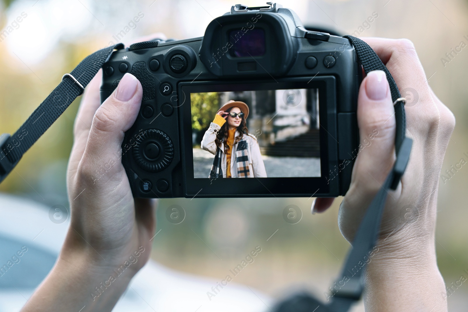 Photo of Professional photographer with digital camera outdoors, closeup