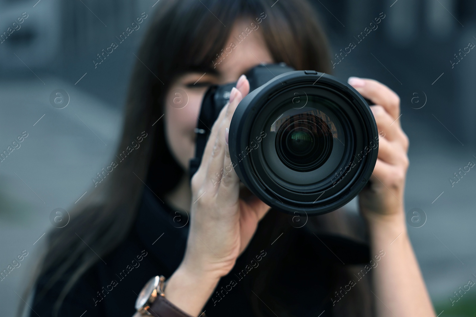 Photo of Professional photographer taking picture with camera outdoors, selective focus