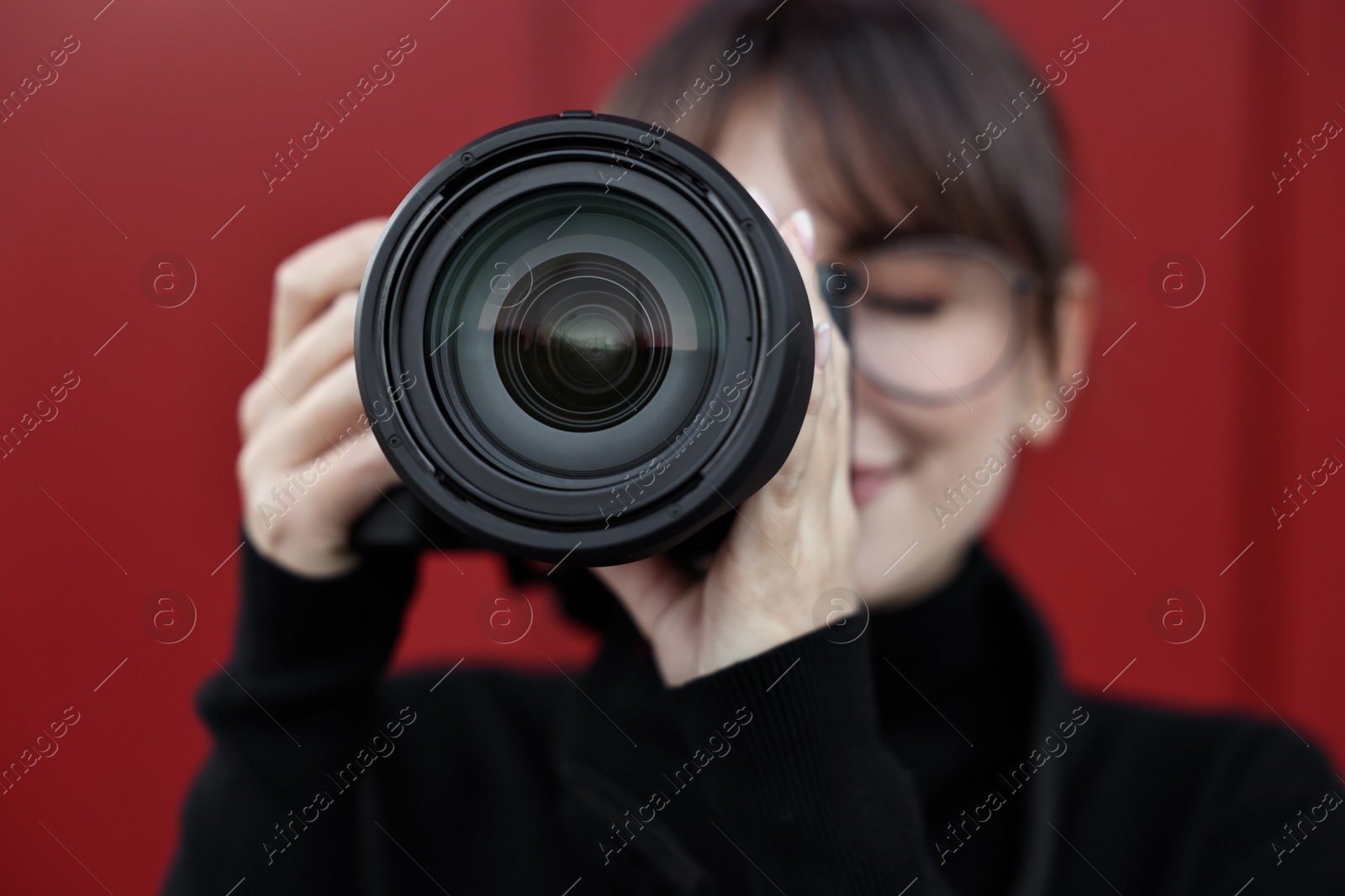 Photo of Professional photographer taking picture with camera outdoors, selective focus