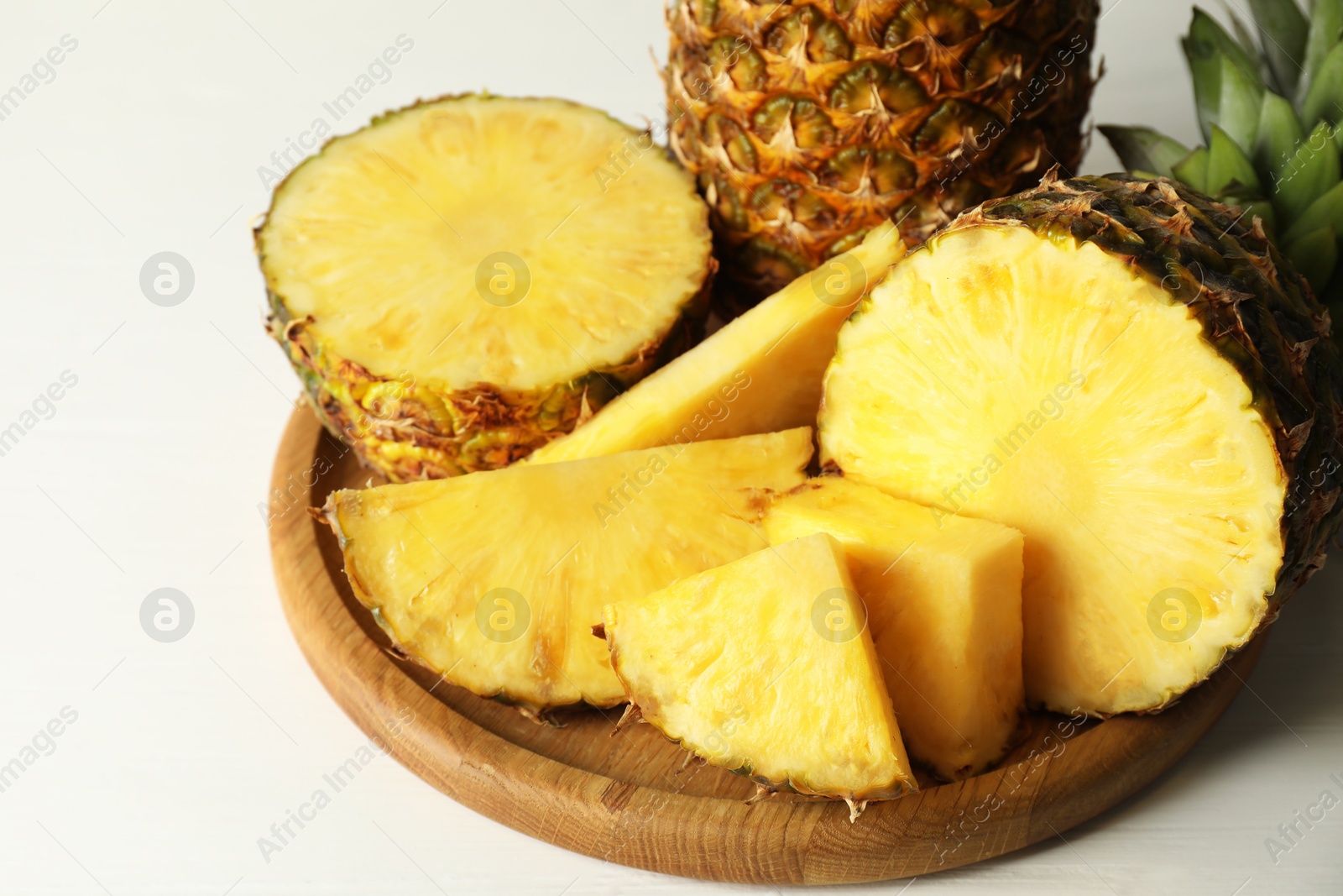 Photo of Fresh ripe pineapples on white table, closeup