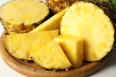 Photo of Cut fresh ripe pineapple on white table, closeup