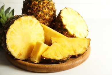 Photo of Fresh ripe pineapples on white table, closeup