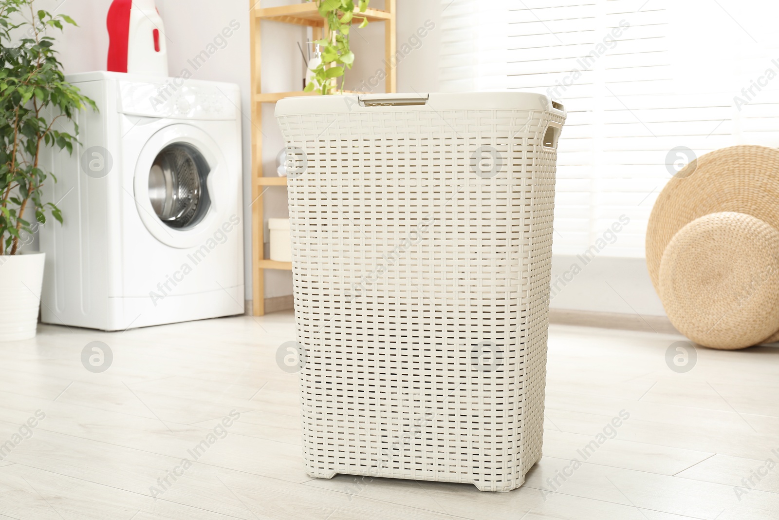 Photo of Wicker laundry basket on floor in bathroom