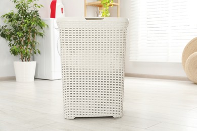 Photo of Wicker laundry basket on floor in bathroom