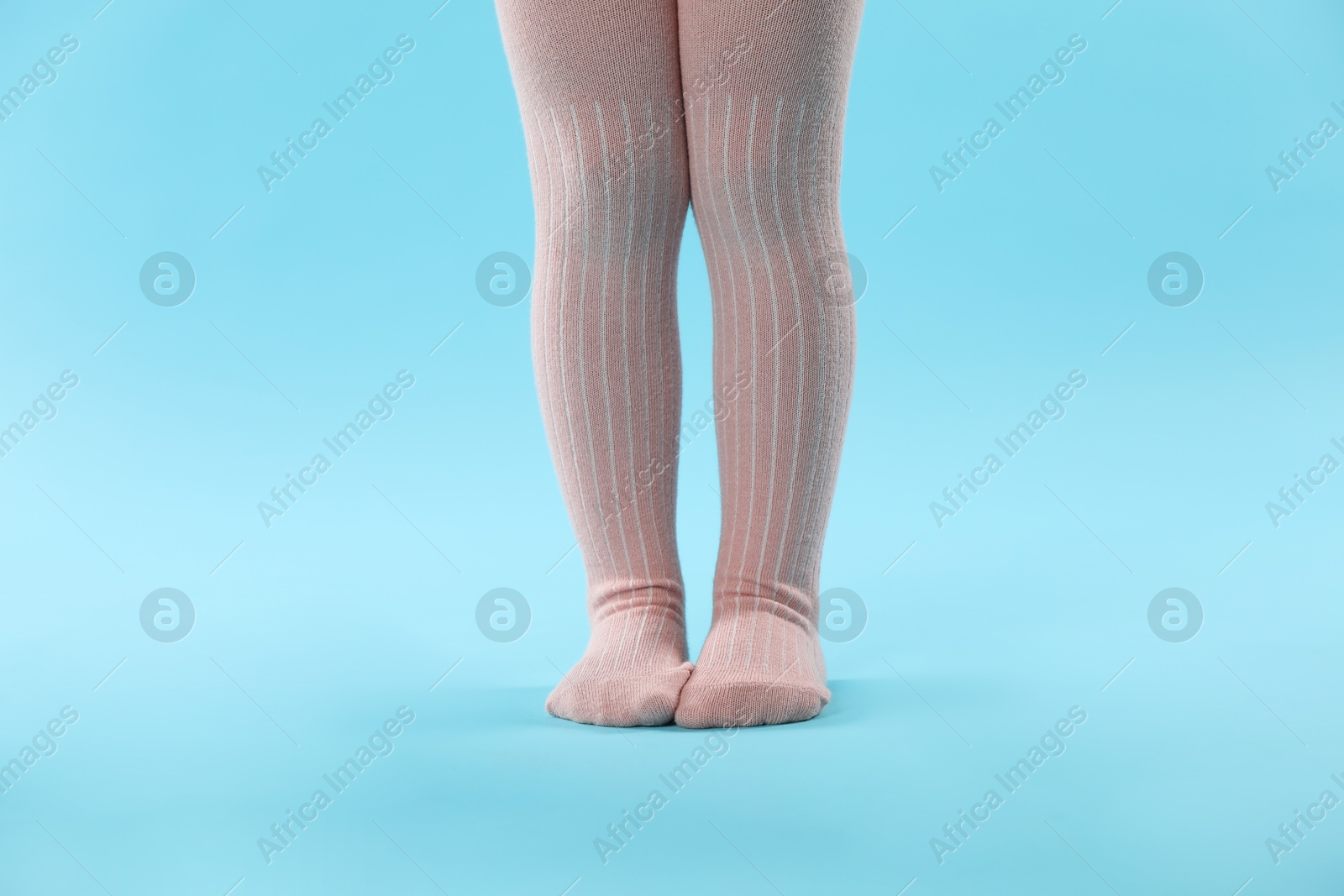 Photo of Child wearing tights on light blue background, closeup