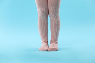 Photo of Child wearing tights on light blue background, closeup