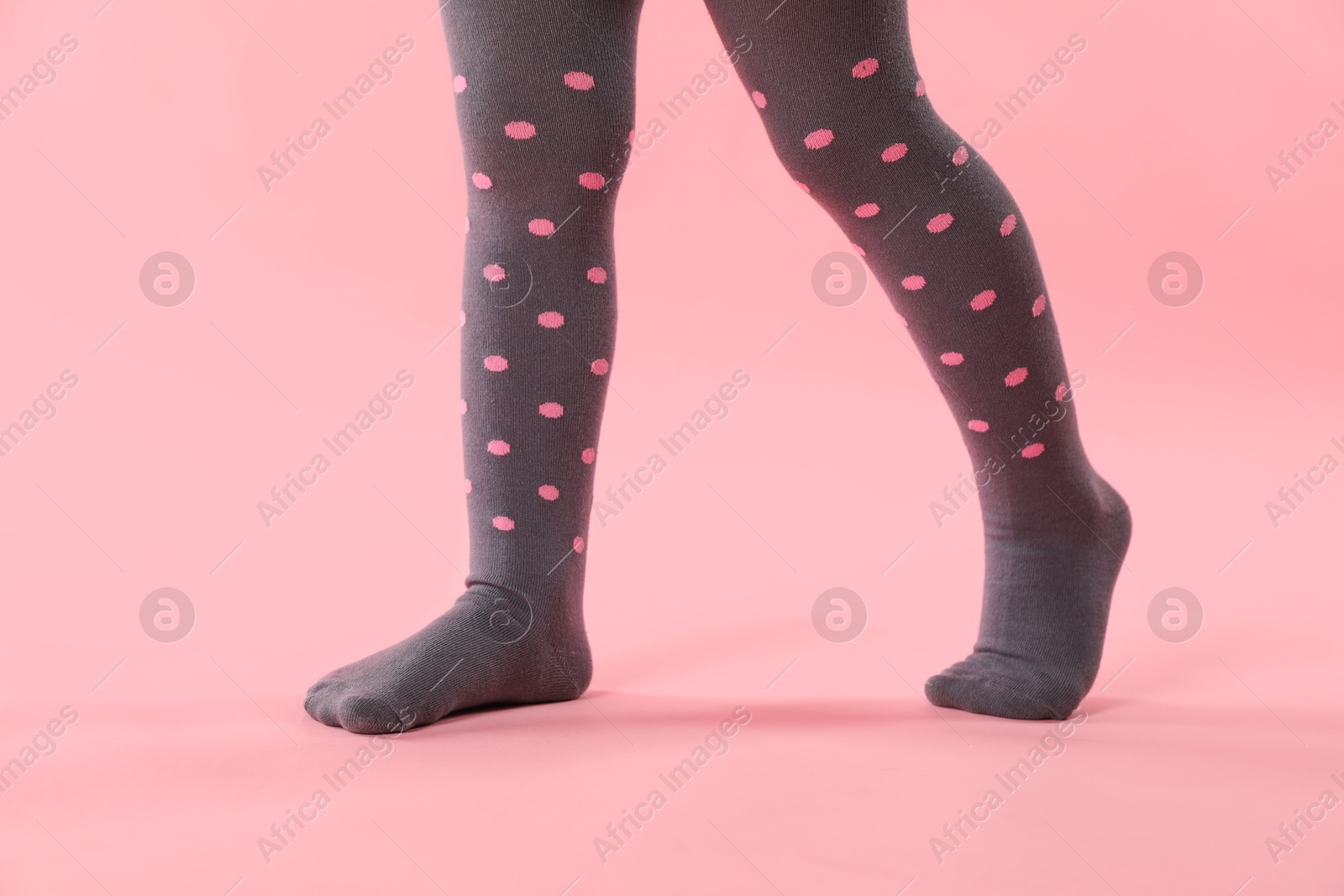 Photo of Child wearing tights on pink background, closeup