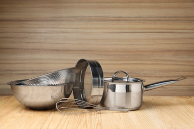 Photo of Dishware and cooking utensils on wooden table