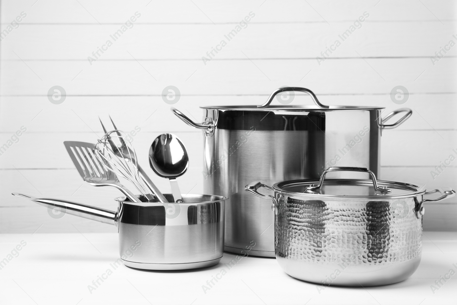 Photo of Dishware and cooking utensils on white table