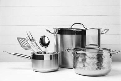 Photo of Dishware and cooking utensils on white table