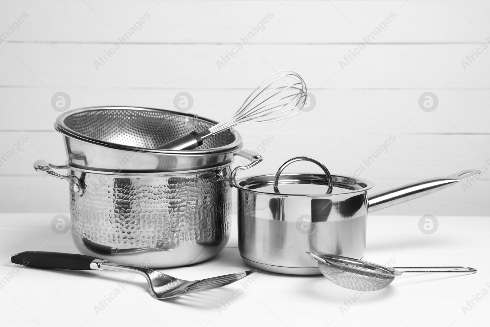 Photo of Dishware and cooking utensils on white table