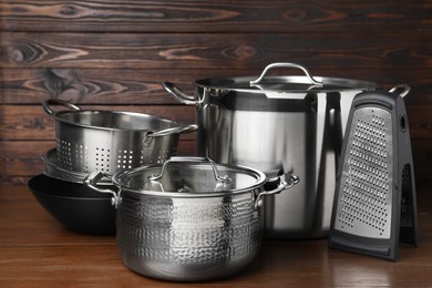 Photo of Dishware and cooking utensils on wooden table