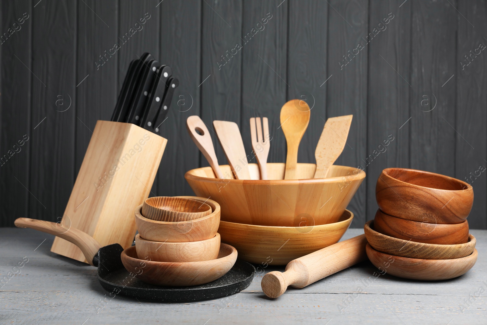 Photo of Dishware and cooking utensils on grey wooden table