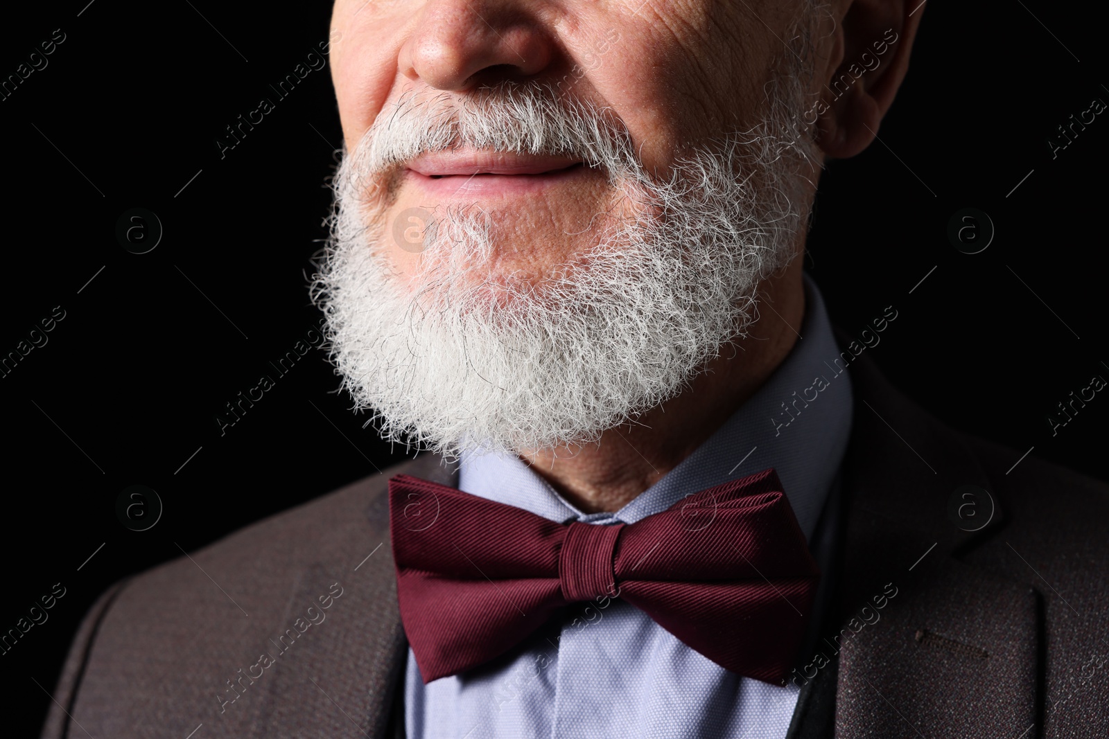 Photo of Senior man with gray beard on black background, closeup