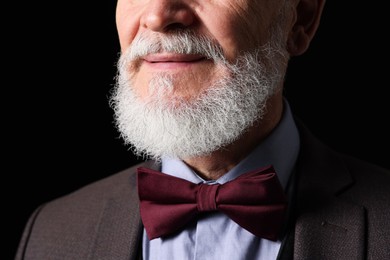 Photo of Senior man with gray beard on black background, closeup