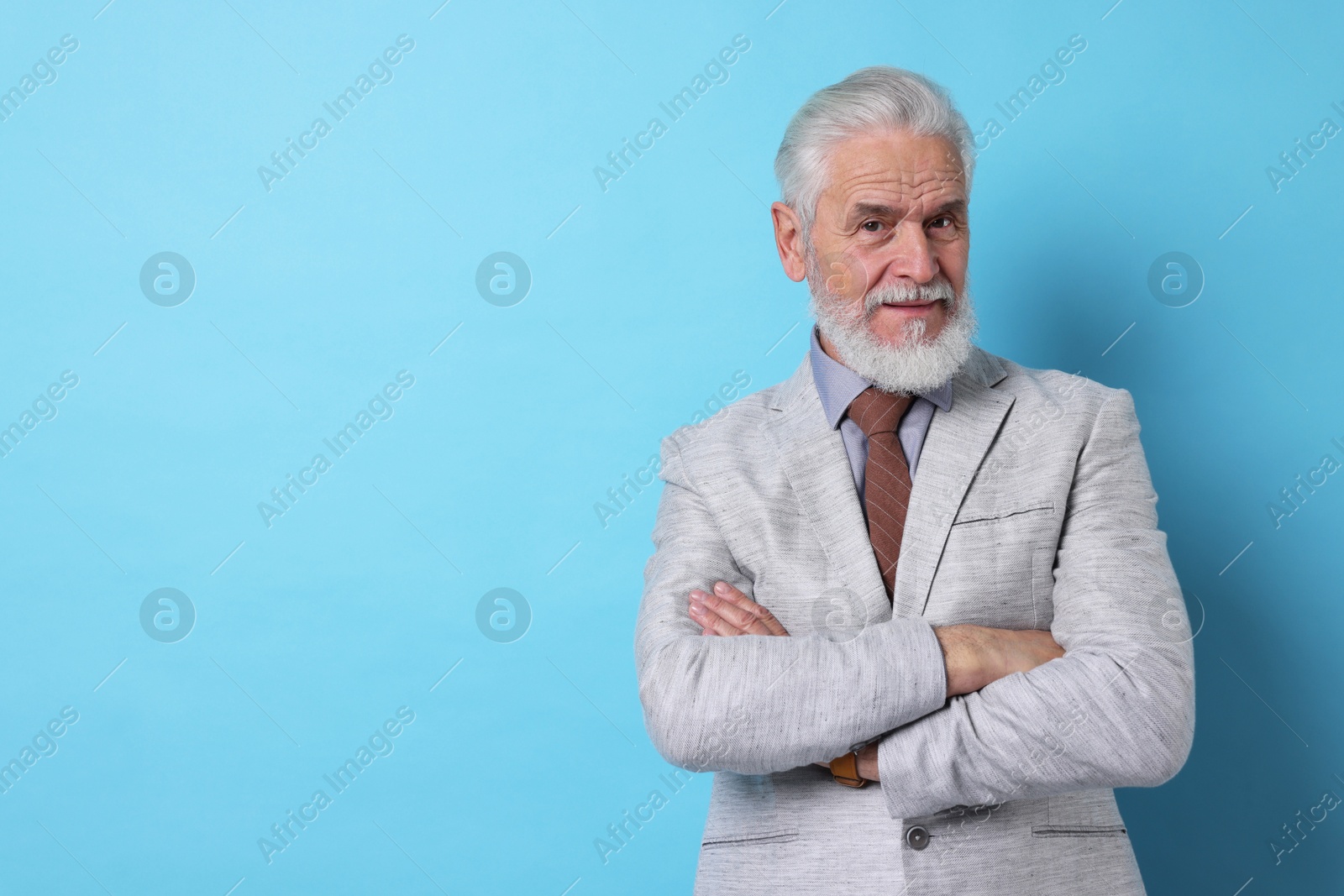 Photo of Portrait of senior man with gray beard on light blue background. Space for text