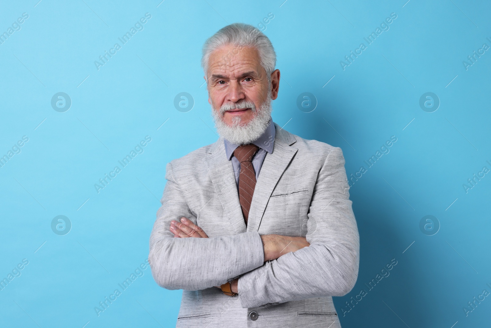 Photo of Portrait of senior man with gray beard on light blue background