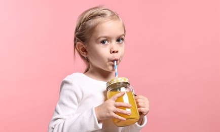 Photo of Girl with mason jar of orange juice on pink background. Refreshing drink